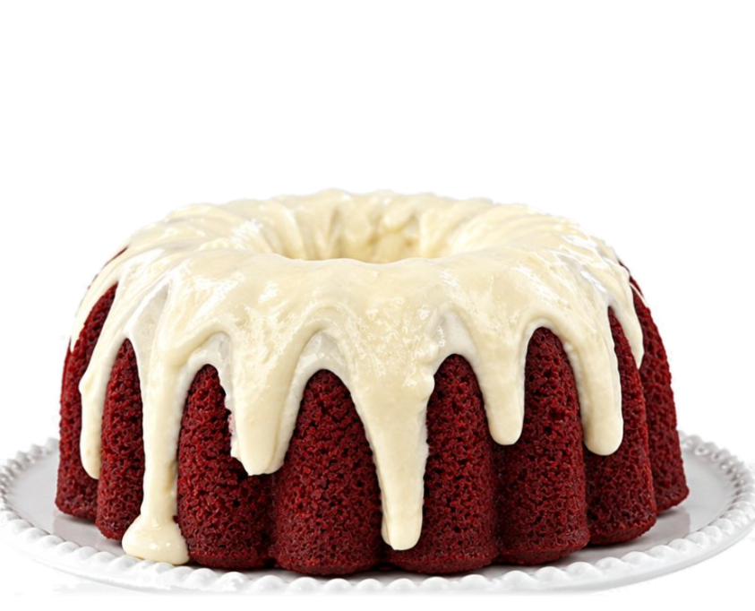 Red velvet bundt cake with cream cheese drip on a cake plate